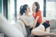 A couple of women sitting on top of a couch.