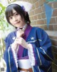 A woman in a blue and purple kimono posing for a picture.