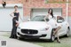 A couple of women standing next to a white car.