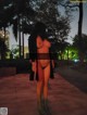 A naked woman walking down a sidewalk at night.