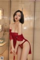 A woman in a red lingerie posing in a bathroom.