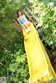 A young woman is sitting on a yellow slide.