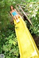 A young woman is sitting on a yellow slide.