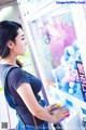 A woman standing in front of a vending machine.