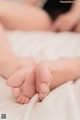 A close up of a person's feet on a bed.