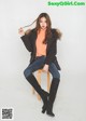 A woman sitting on top of a wooden stool.