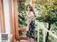 a woman standing on a balcony next to a window