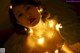 A woman laying on top of a bed covered in lights.