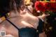 A woman in a black bra holding a bouquet of flowers.