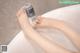 A woman's feet in a bathtub with a bottle of water.