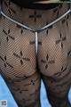 A close up of a woman wearing fishnet stockings and a thong.