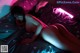 A naked woman laying on a bed under a neon light.