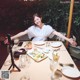 A woman sitting at a table with a plate of food.